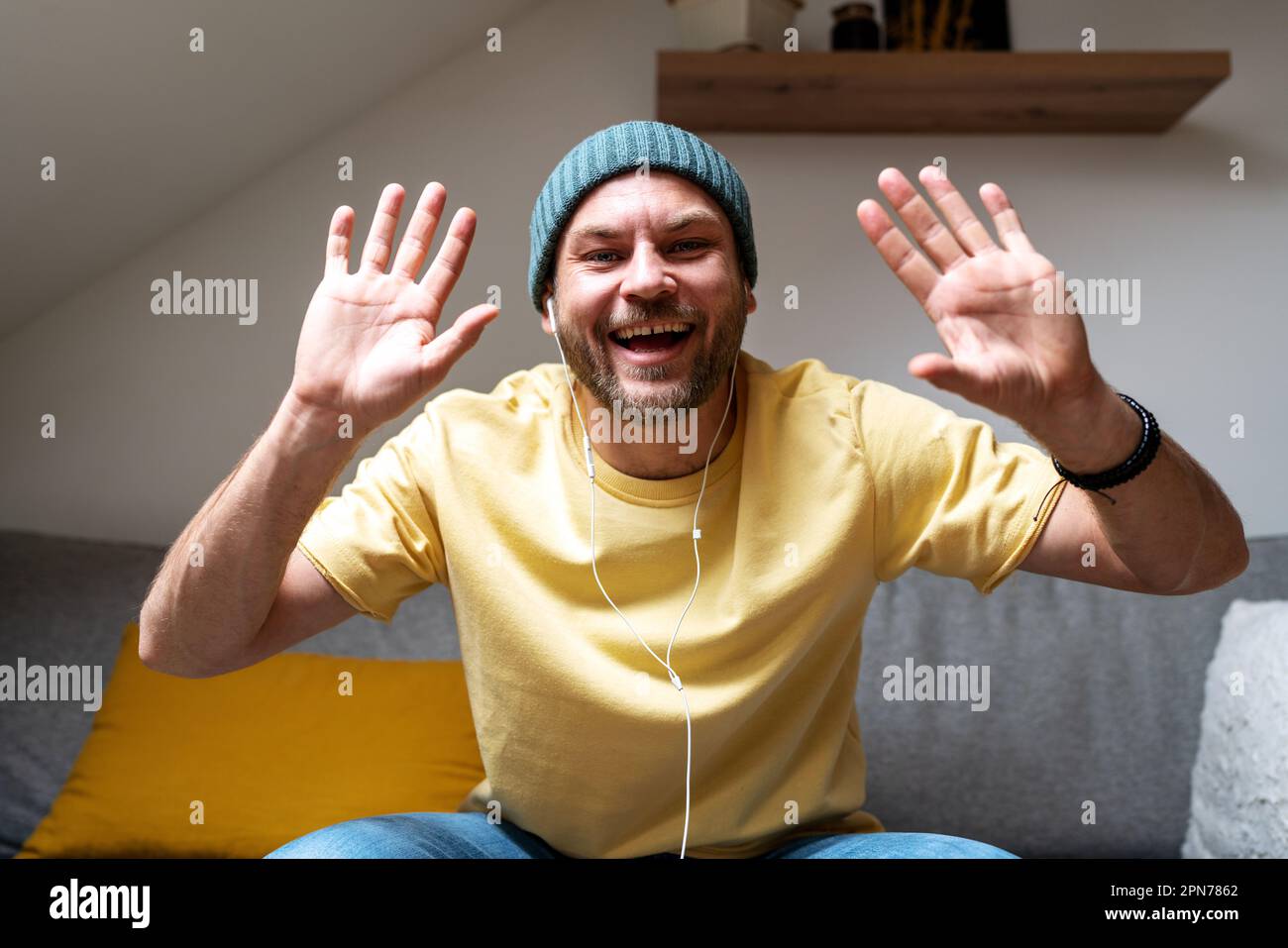 L'uomo sorride e agita le mani durante la riunione online. Foto Stock