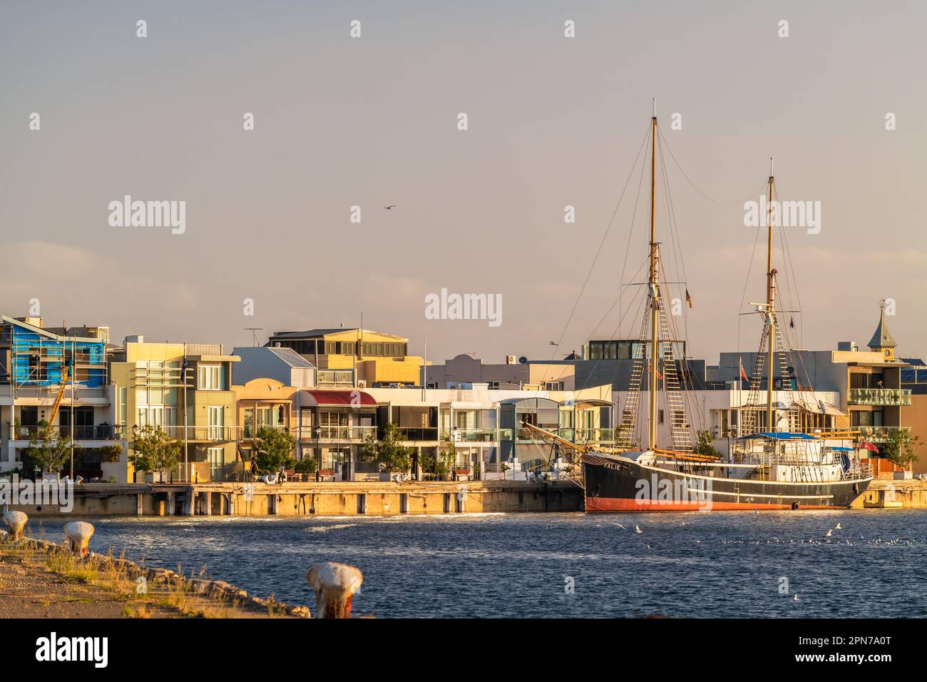 Port Adelaide, Australia - 11 aprile 2020: Port Adelaide attracca con le case e la nave Falie attracca nel Port River al tramonto Foto Stock