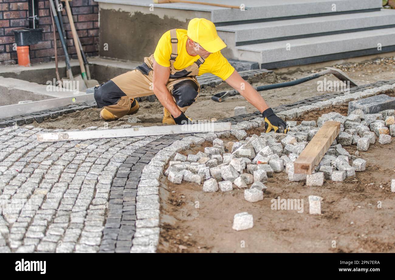 Appaltatore professionista costruire un passerella di pietre di pavimentazione di fronte alla casa. Tema di miglioramento Casa. Foto Stock