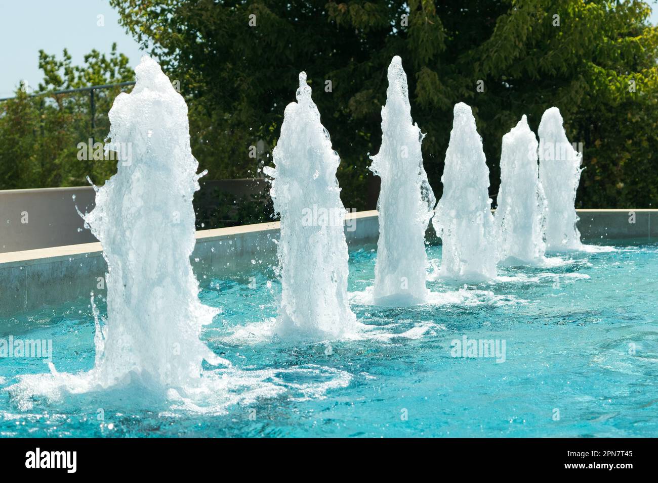 Vista di una fontana con acqua blu in un giorno d'estate Foto Stock