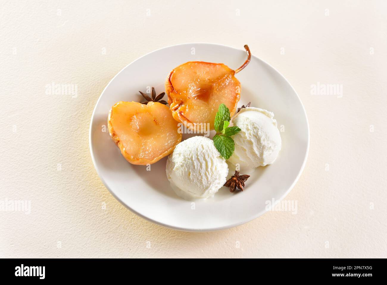 Gelato con pere in camicia su piatto su sfondo chiaro. Vista ravvicinata Foto Stock