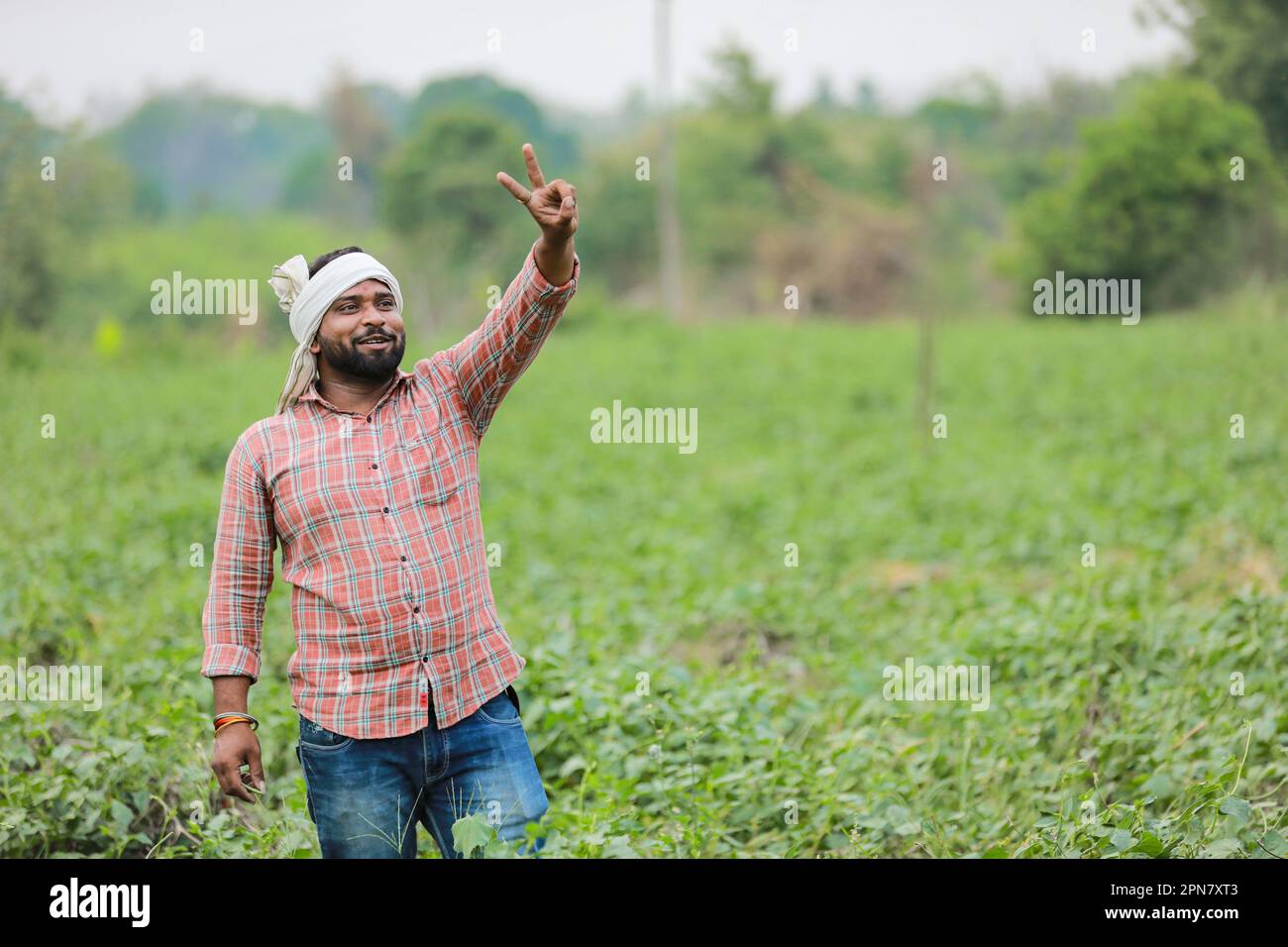 Felice agricoltore indiano, giovane agricoltore sorridente in fattoria Foto Stock