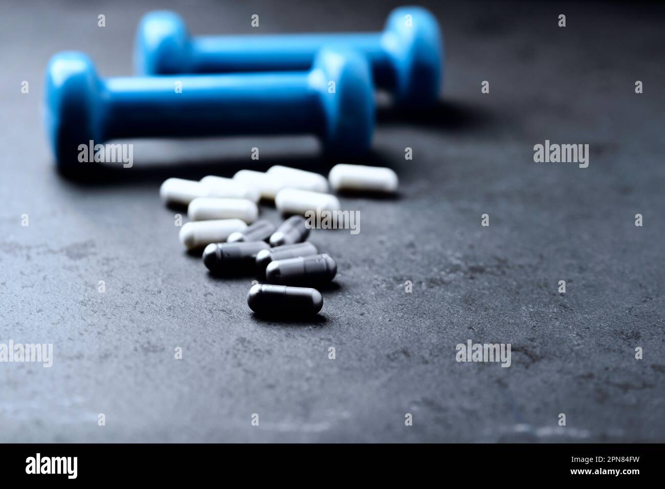 Capsule di BCAA e creatie. Bodybuilding integratori alimentari su sfondo di pietra scura. Messa a fuoco morbida. Primo piano. Spazio di copia. Foto Stock