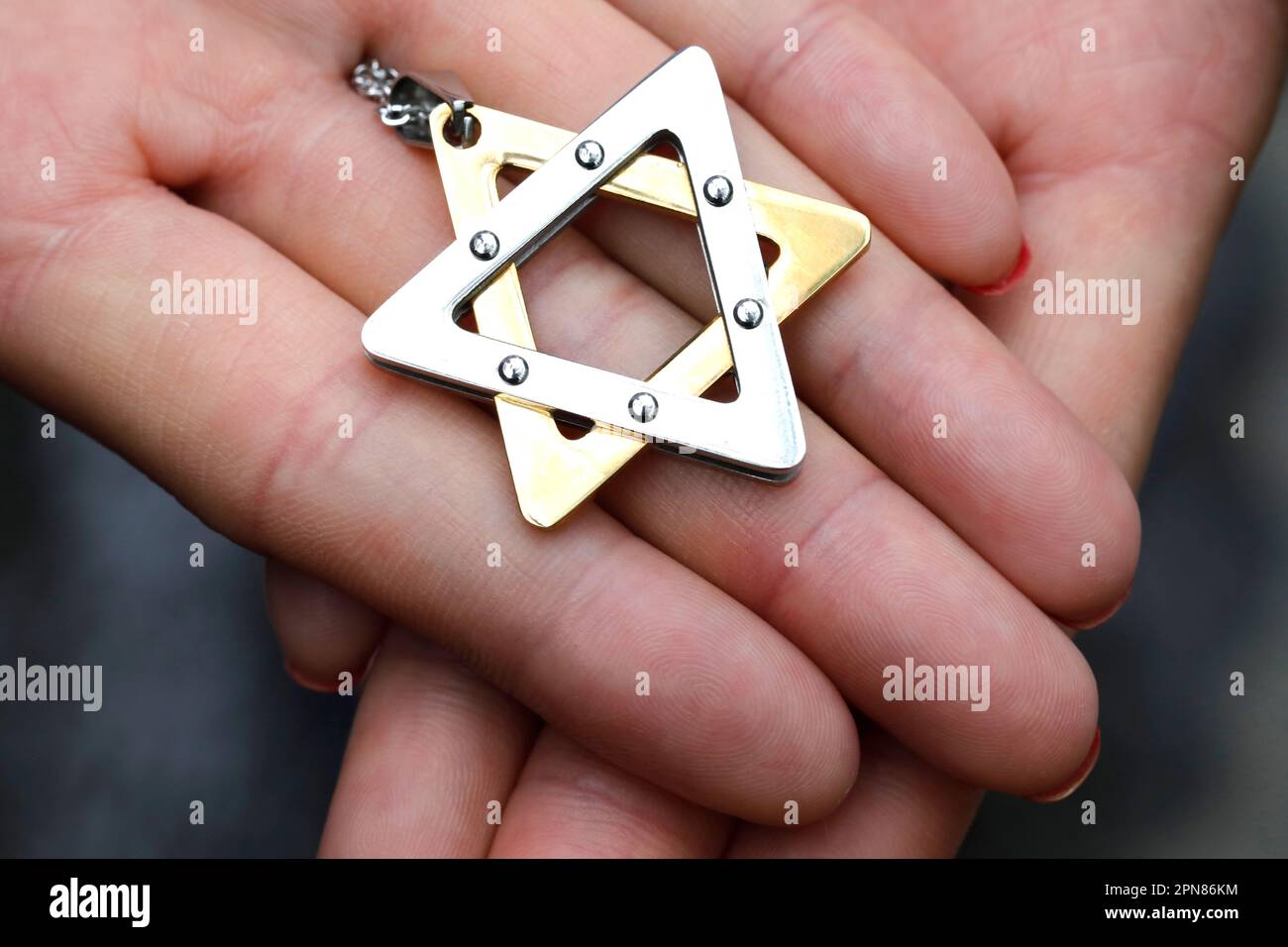 Donna con una stella di Davide o una stella ebraica pendente. Primo piano sulle mani. Foto Stock