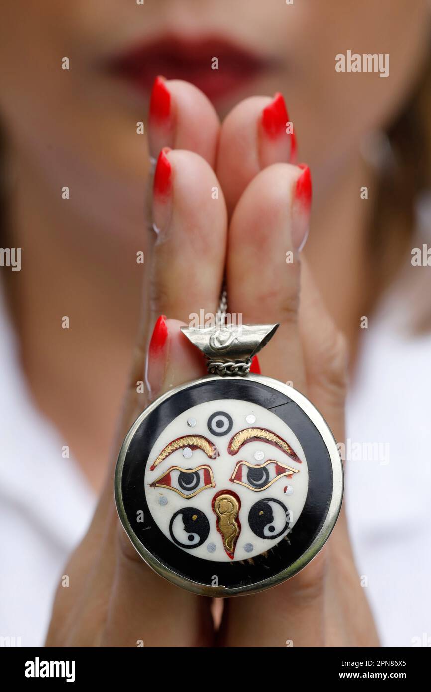 Donna con ottone tibetano e occhio argentato del pendente del mantra di buddha. Simbolo del Buddismo. Foto Stock