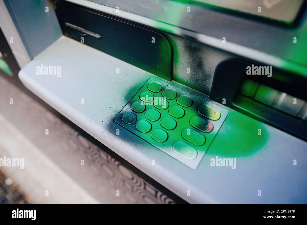 Una città francese ATM, danneggiato durante una dimostrazione e coperto di vernice verde graffiti. La tastiera è in attesa di essere rimossa in modo che il dispositivo possa essere riutilizzato dai clienti Foto Stock