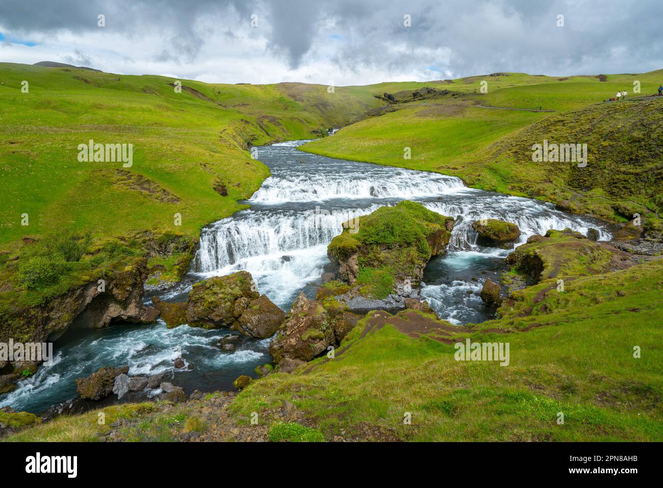 Il fiume selvaggio scorre attraverso il paesaggio verde dell'Islanda. Fiume Skoga da Laugavegur sentiero appena sopra la famosa cascata Skogafoss. Foto Stock