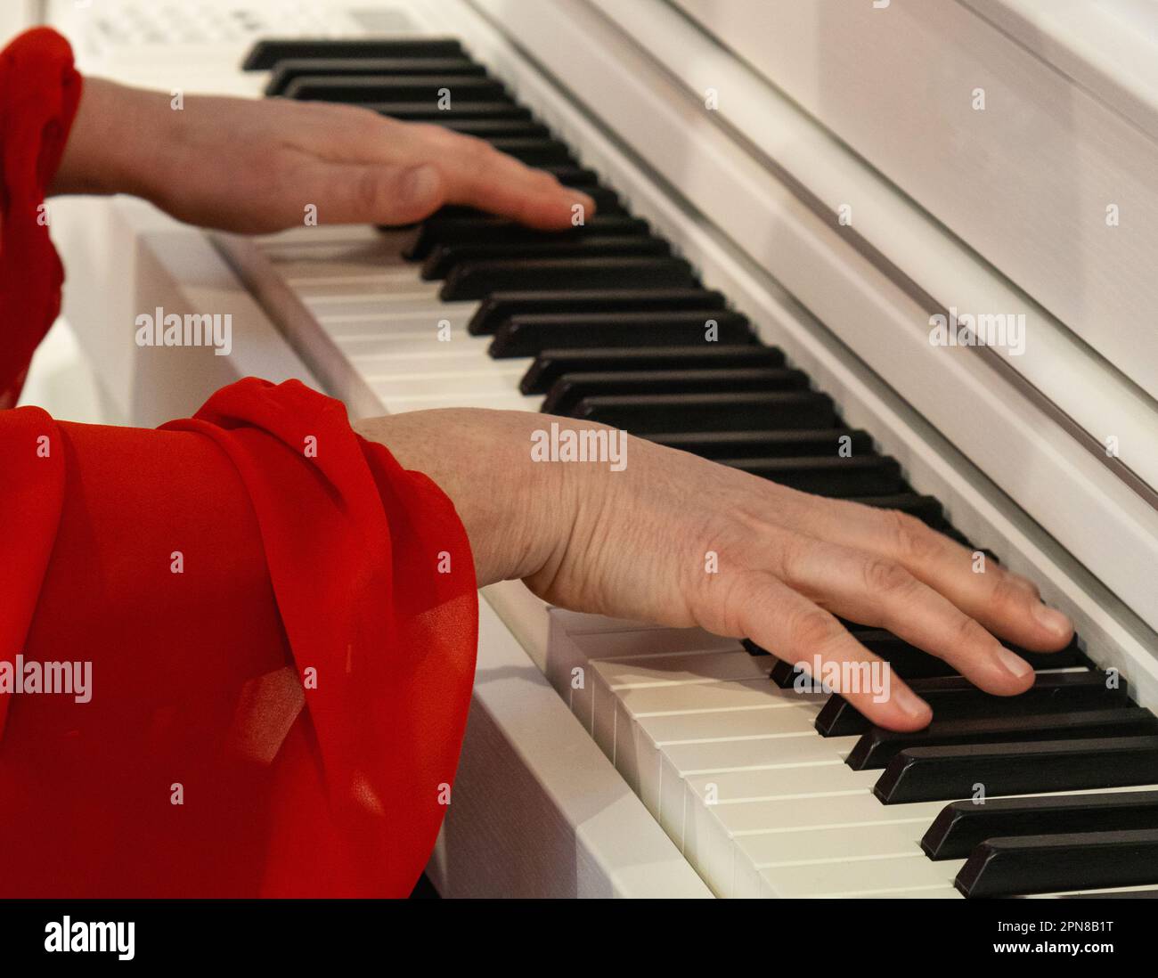 Suonare il pianoforte è un'attività musicale che implica usare le dita per premere i tasti che producono il suono. Foto Stock