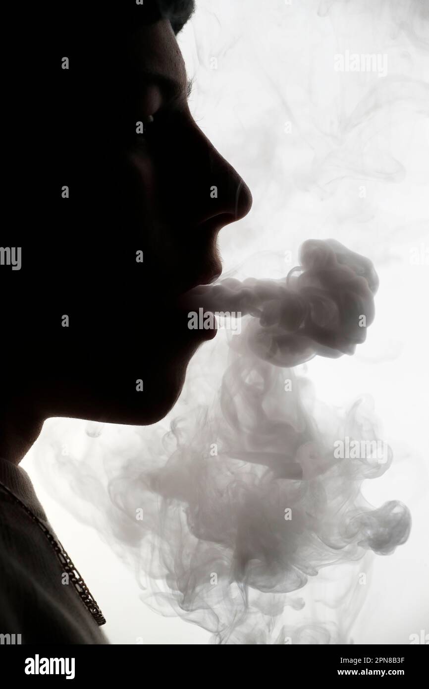 Profilo Silhouette di un uomo che fuma su sfondo bianco. Foto Stock