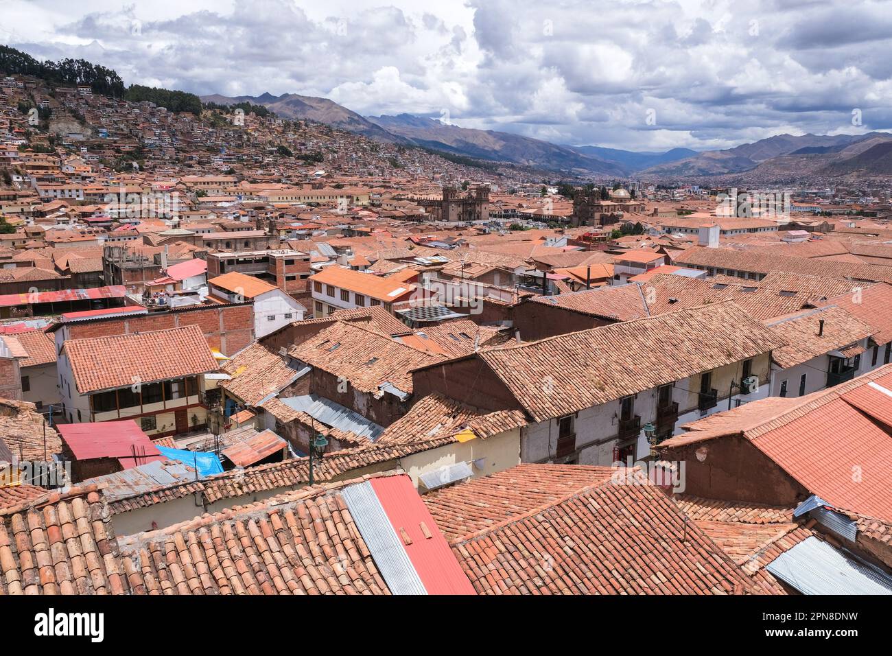 Vista dall'alto le case storiche e il tetto di Cusco con la cattedrale di Cusco, le Ande e lo sfondo del cielo nuvoloso. Vista Cusco concetto di viaggio sfondo. Foto Stock