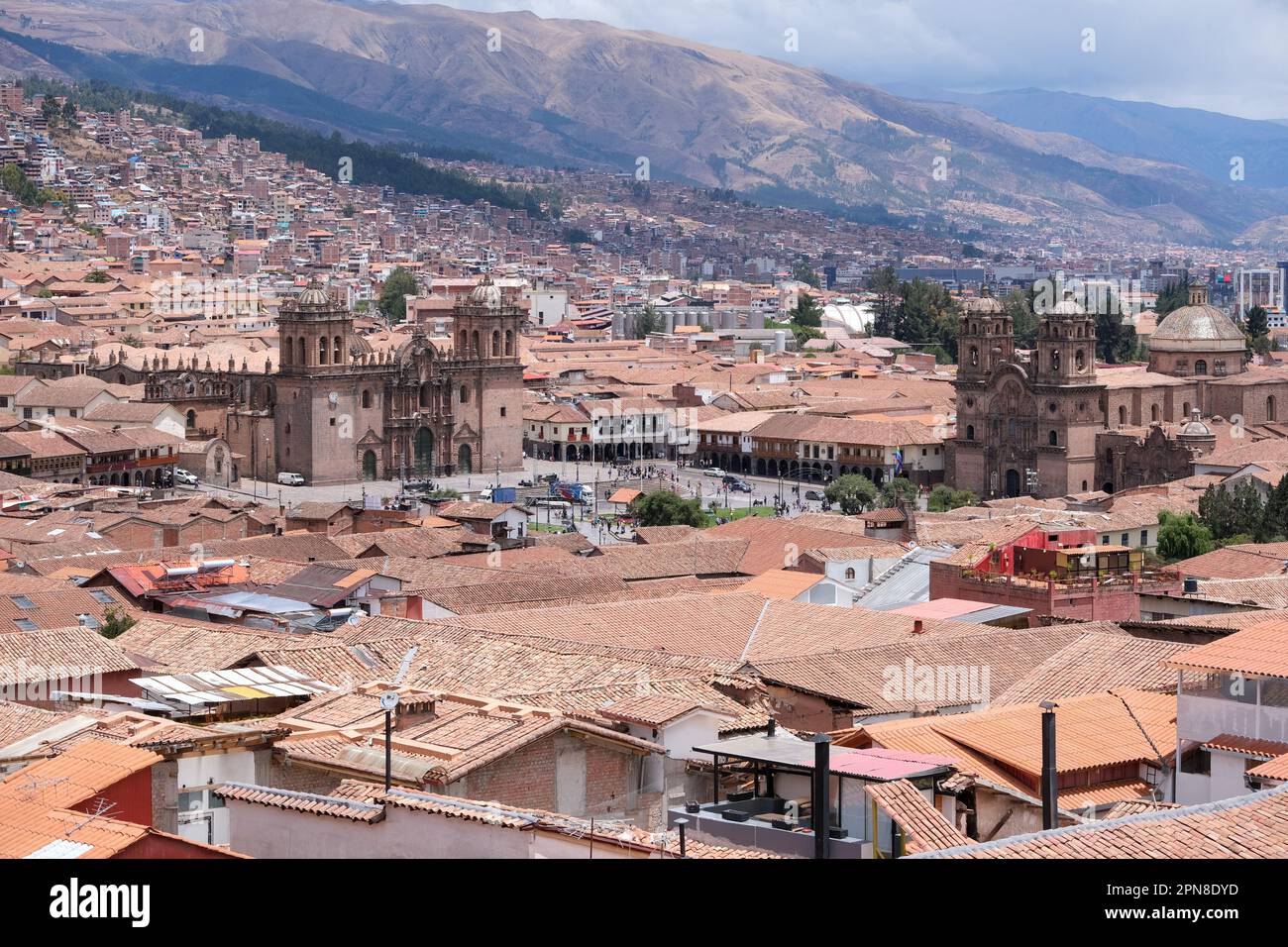 Vista dall'alto le case storiche e il tetto di Cusco con la cattedrale di Cusco, le Ande e lo sfondo del cielo nuvoloso. Vista Cusco concetto di viaggio sfondo. Foto Stock