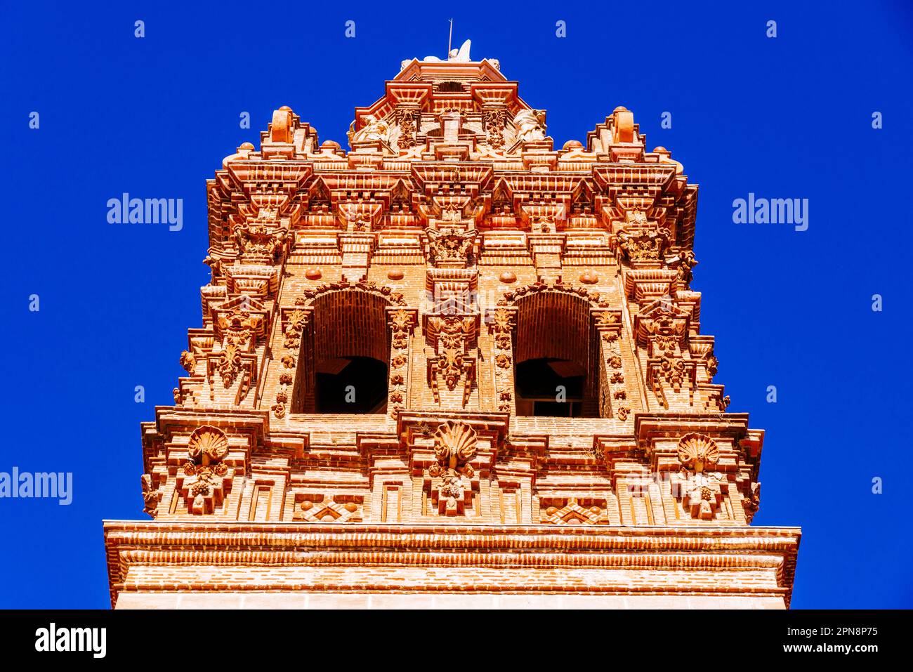 Particolare del campanile barocco. La Chiesa di San Miguel Arcángel è un tempio cattolico in stile barocco. Jerez de los Caballeros, Badajoz, Estremadu Foto Stock