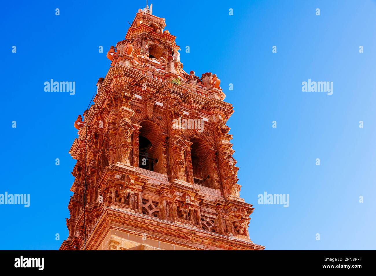 Particolare del campanile barocco. La Chiesa di San Miguel Arcángel è un tempio cattolico in stile barocco. Jerez de los Caballeros, Badajoz, Estremadu Foto Stock