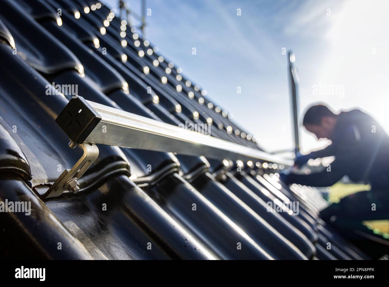 Installazione di strutture di supporto pannelli solari su un tetto a tegole Foto Stock