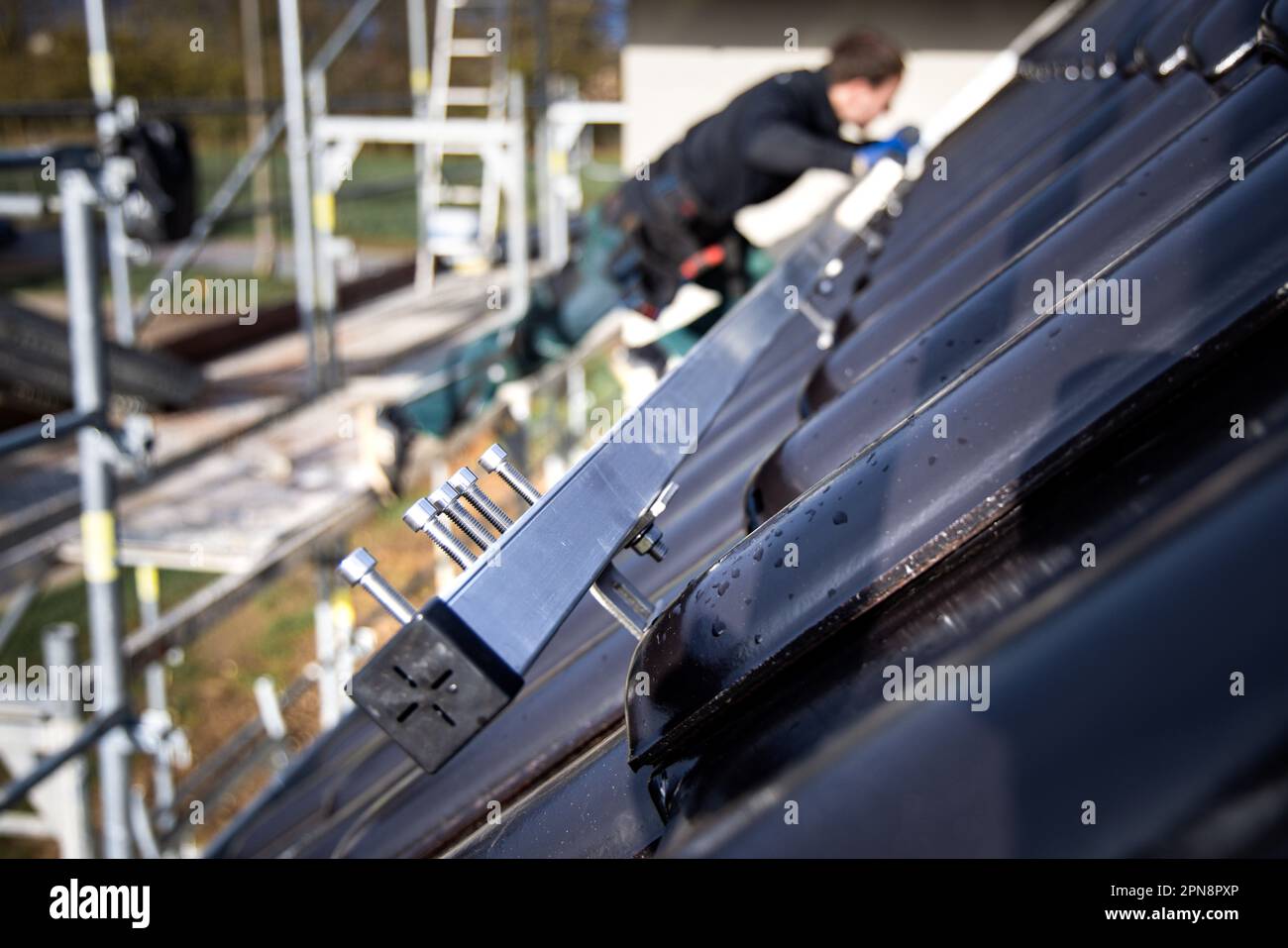 Installazione di sottostrutture di pannelli solari su un tetto a tegole Foto Stock