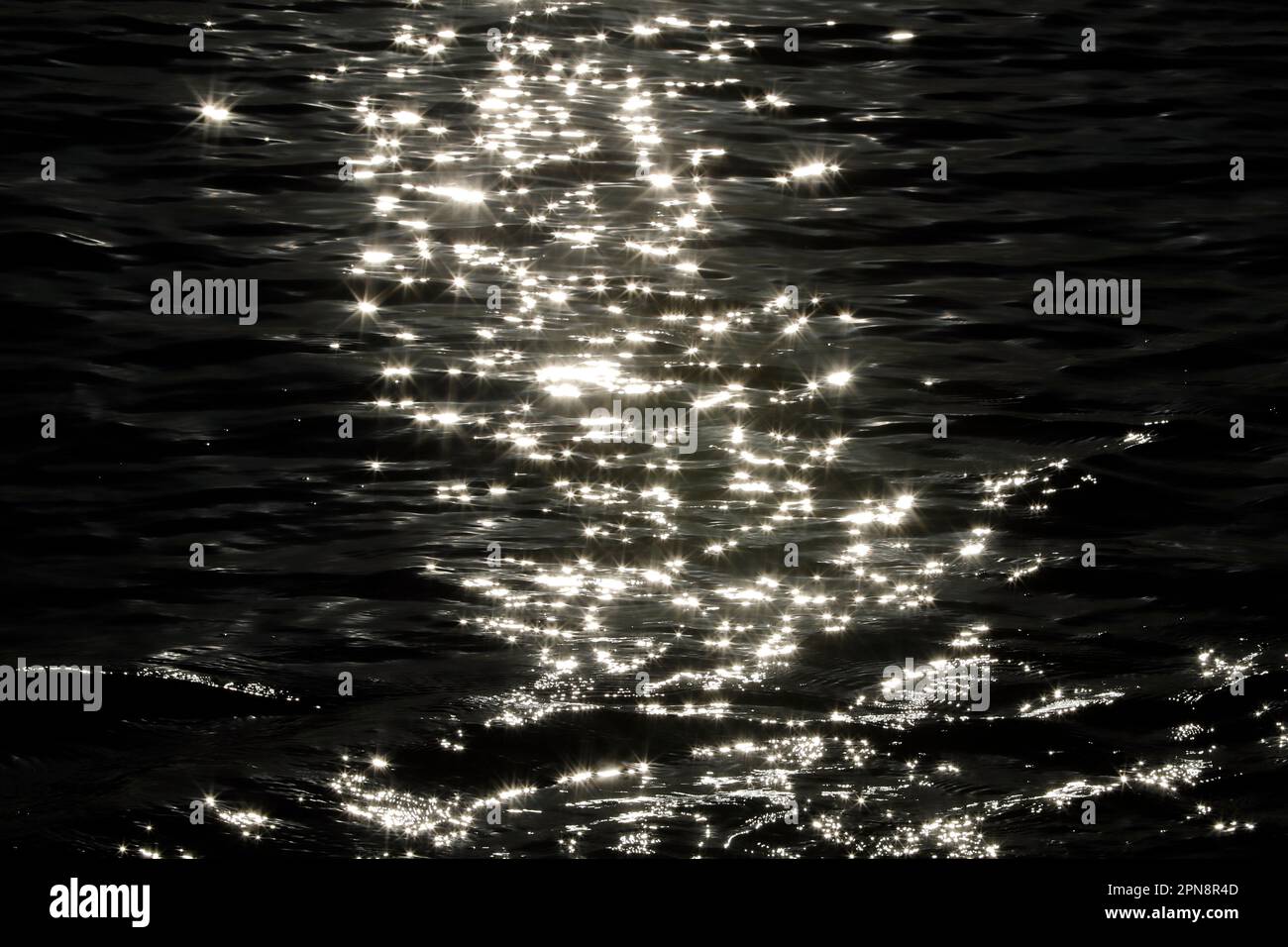 Primo piano delle dolci onde del mare al tramonto. Riflessi di luce sull'acqua. Isole Cayman. Foto Stock