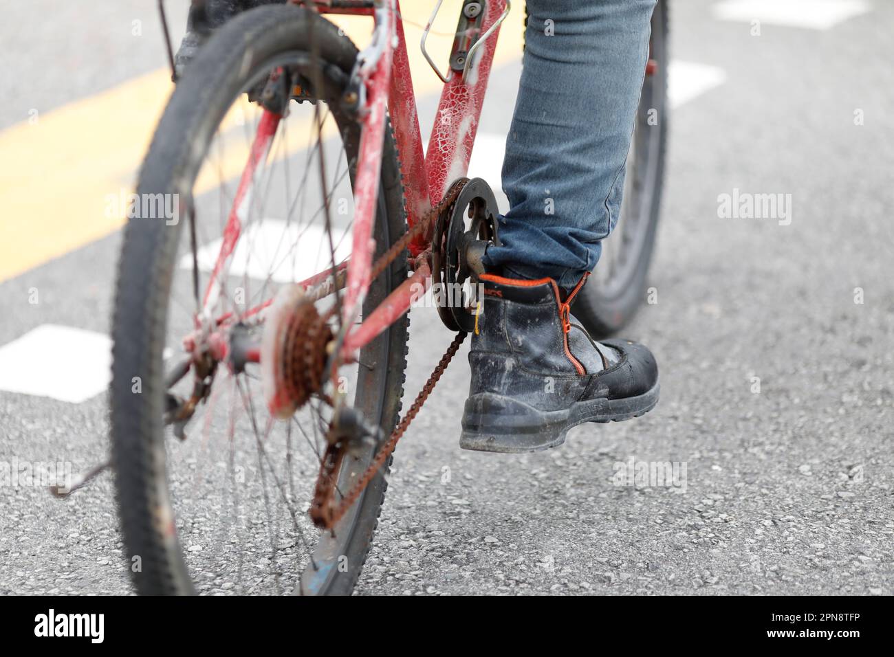 Piede sul pedale della bicicletta. Primo piano della bicicletta tagliata che si muove su strada. Singapore. Foto Stock