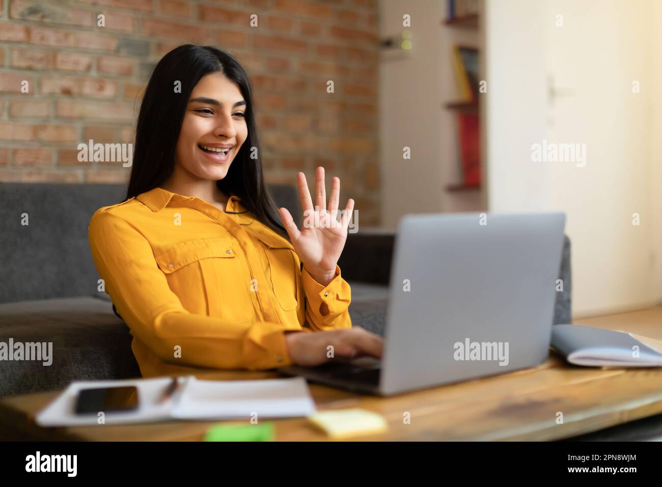 Ragazza messicana eccitato adolescente che ha videochiamata e le mani agitate al laptop Webcamera, studiando online da casa Foto Stock