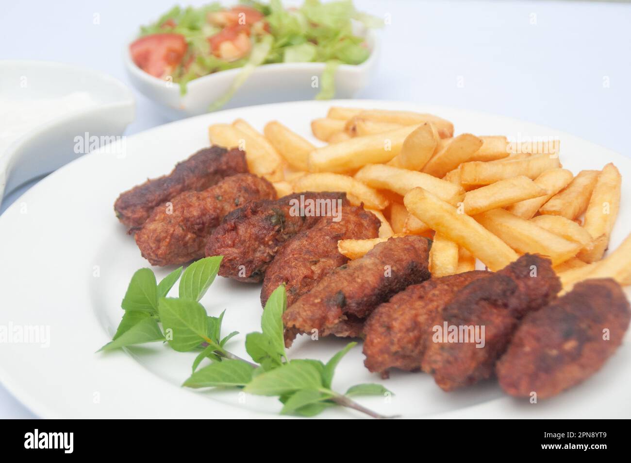 Kofte servito con patate fritte, insalata e yogurt Foto Stock