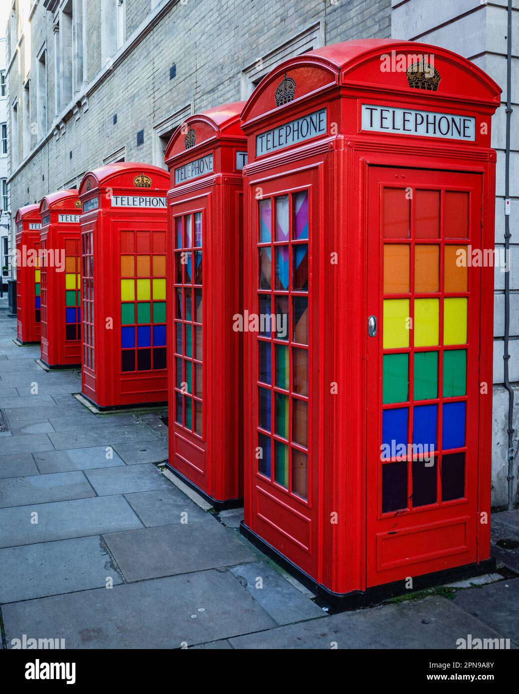 La cassetta telefonica rossa disegnata da Sir Giles Gilbert Scott con i colori lgbtqia sulla Broad Street vicino al Royal Opera House a Covent Garden. Foto Stock