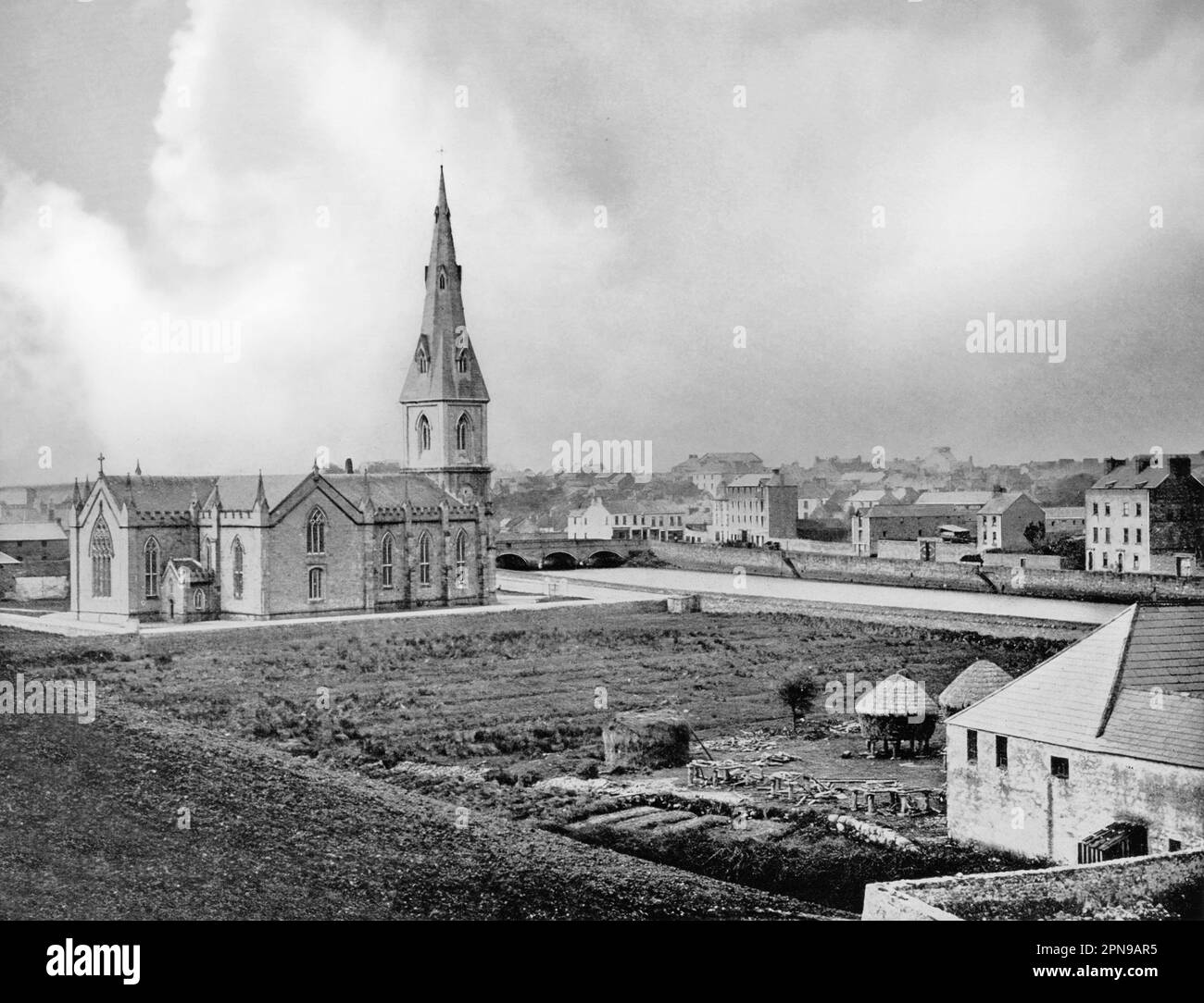 Una vista del tardo 19th ° secolo di Ballina, una città nella contea nord di Mayo, Irlanda che si trova alla foce del fiume Moy vicino Killala Bay. La cattedrale di San Muredach, nella foto, fu completata prima della Grande carestia nel 1845, con la guglia nel 1855. Foto Stock