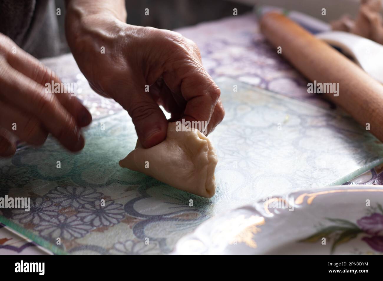 le mani di vecchia nonna stanno facendo torte sul tavolo Foto Stock