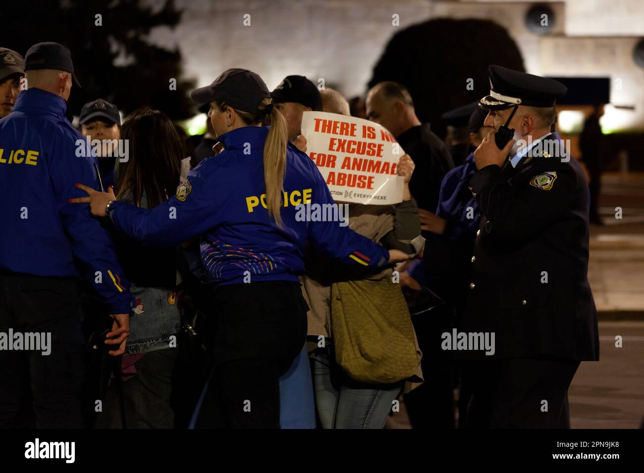 Protesta degli attivisti vegani contro gli abusi sugli animali e il consumo di carne durante i festeggiamenti pasquali, mentre i poliziotti in uniforme blu li spingono indietro. Foto Stock