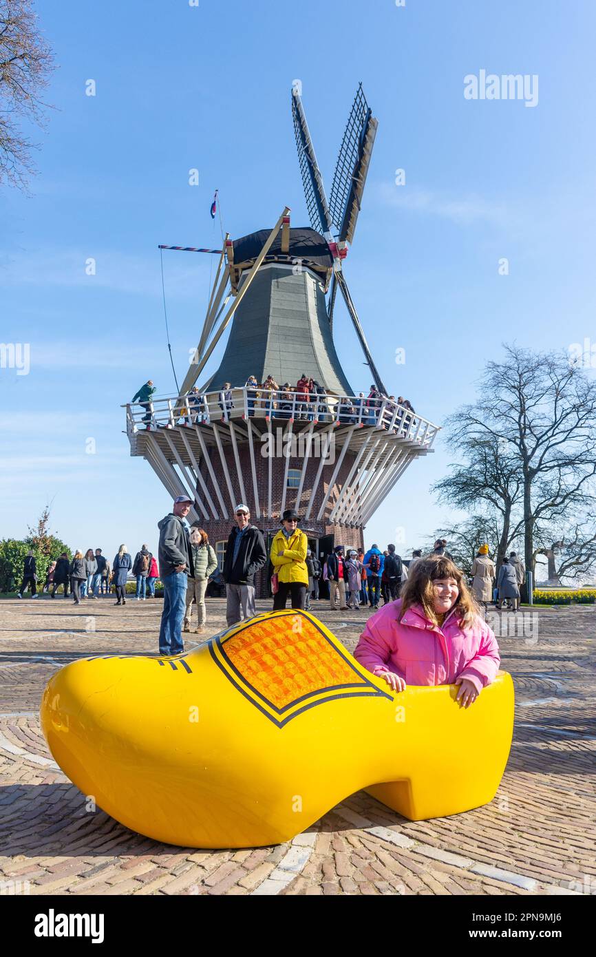 Giovane ragazza che posa in un gigantesco zoccolamento presso il Mulino, Giardini Keukenhof, Lisse, Olanda del Sud (Zuid-Olanda), Regno dei Paesi Bassi Foto Stock