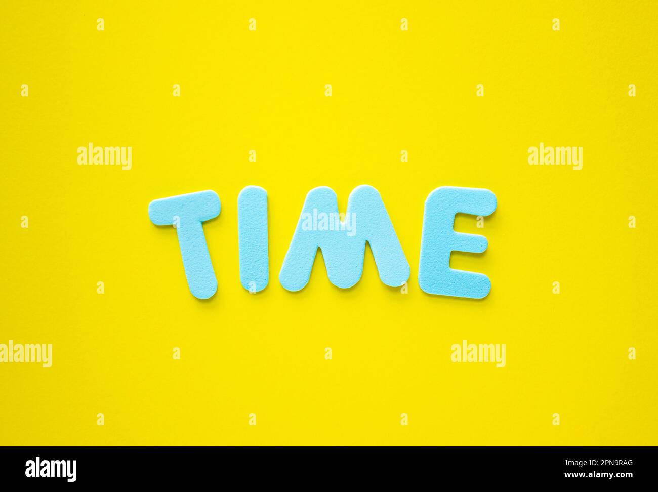 TESTO TEMPORALE con lettere blu su sfondo giallo, concetto di business con spazio di copia. Concetto di tempo. Primo piano dello spazio di copia, gestione del tempo. Foto Stock