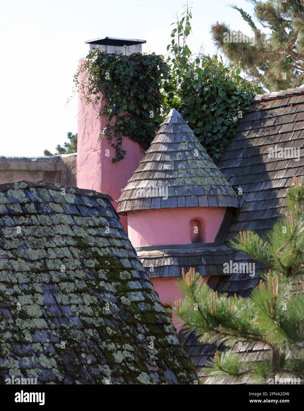 Affascinante torretta rosa e camino situato nel tetto di un edificio del centro nel villaggio sul mare di Carmel-by-the-Sea, CA. Foto Stock