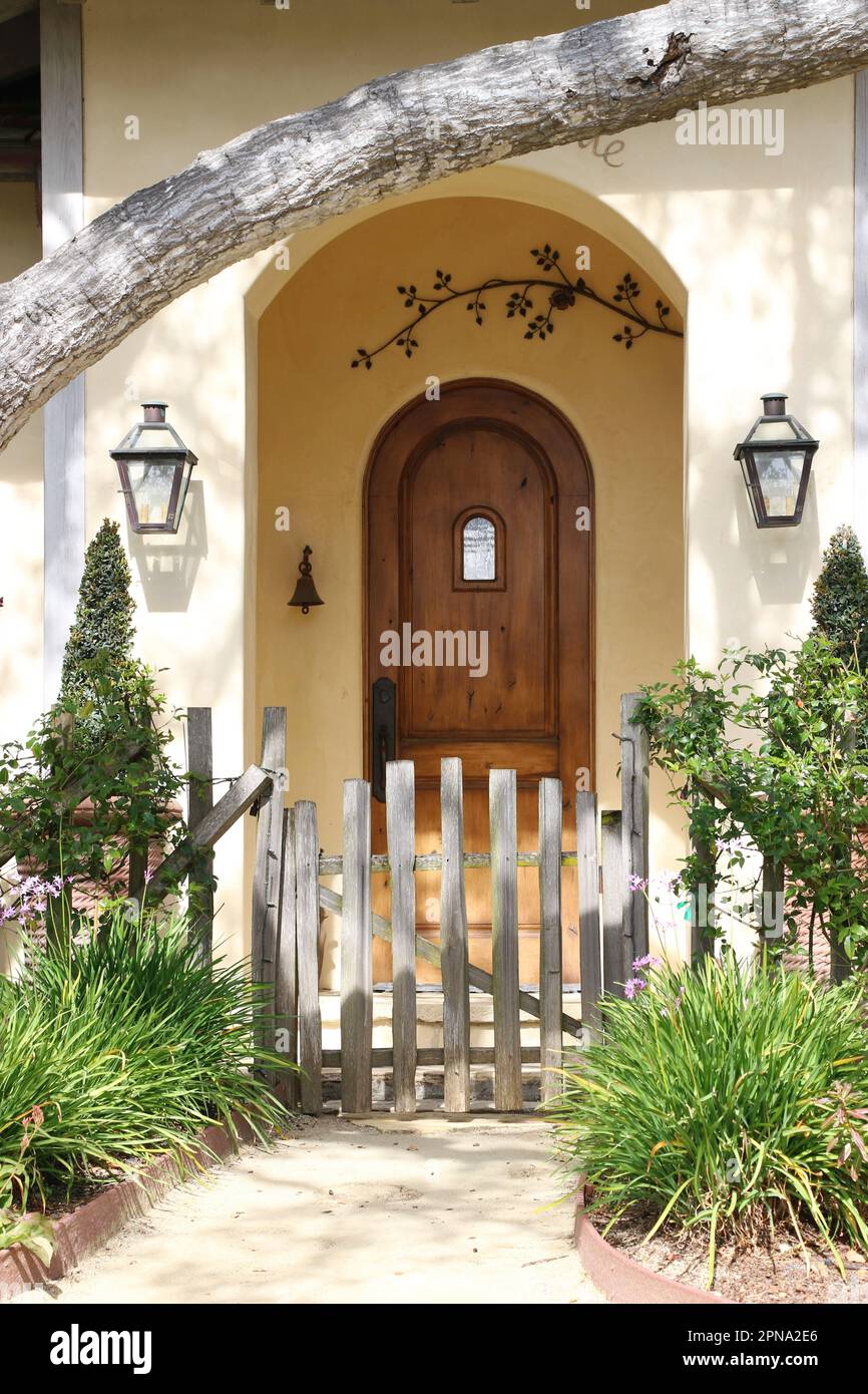 La porta arrotondata incassata in un portico fornisce un invitante accesso a un affascinante cottage a Carmel-by-the-Sea, CA, un affascinante villaggio costiero. Foto Stock
