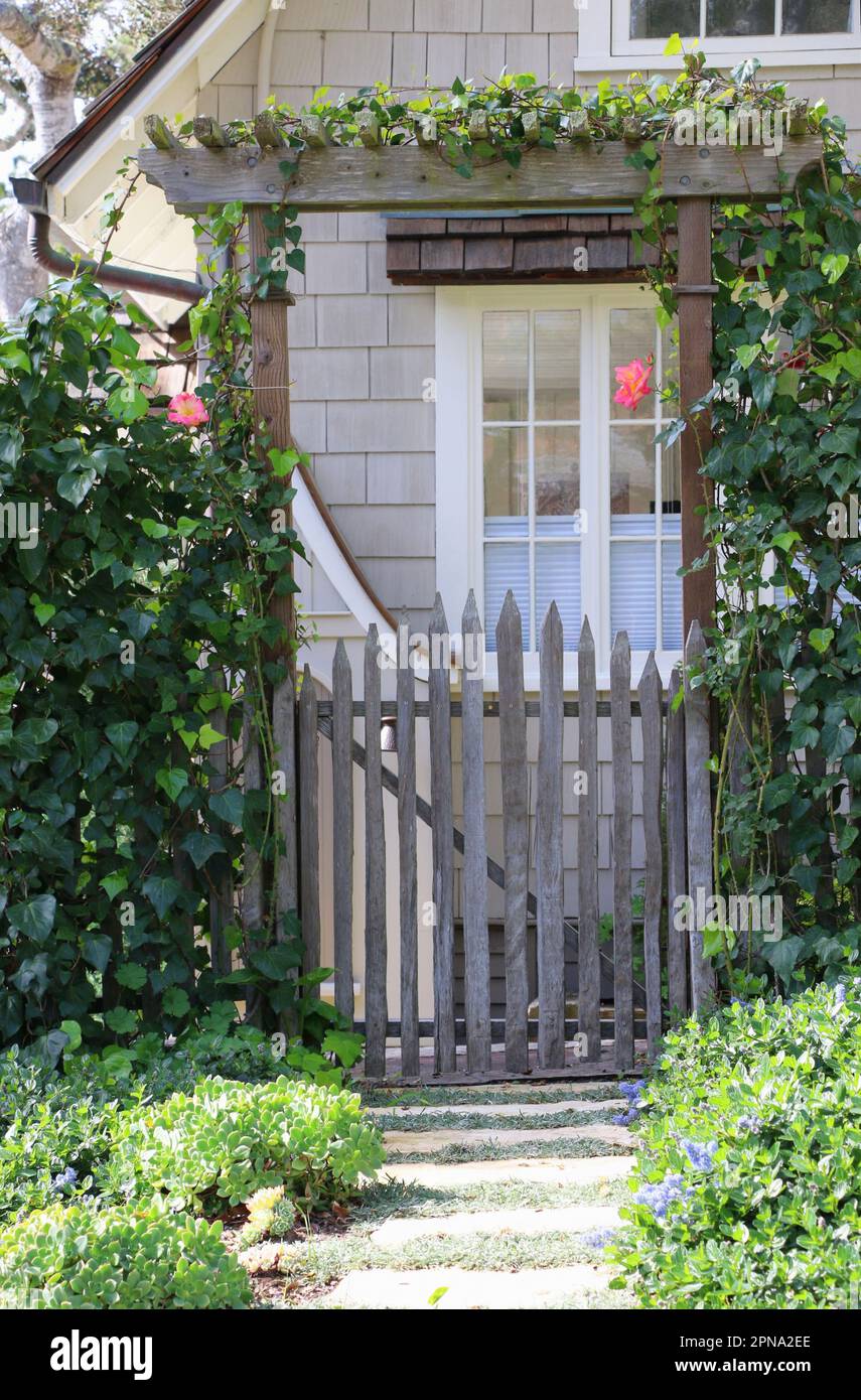 Il cancello d'ingresso al giardino con edera da arrampicata fornisce un'entrata graziosa ad una casa pittoresca, a Carmel-by-the-Sea, un affascinante villaggio sul mare nel nord della California. Foto Stock
