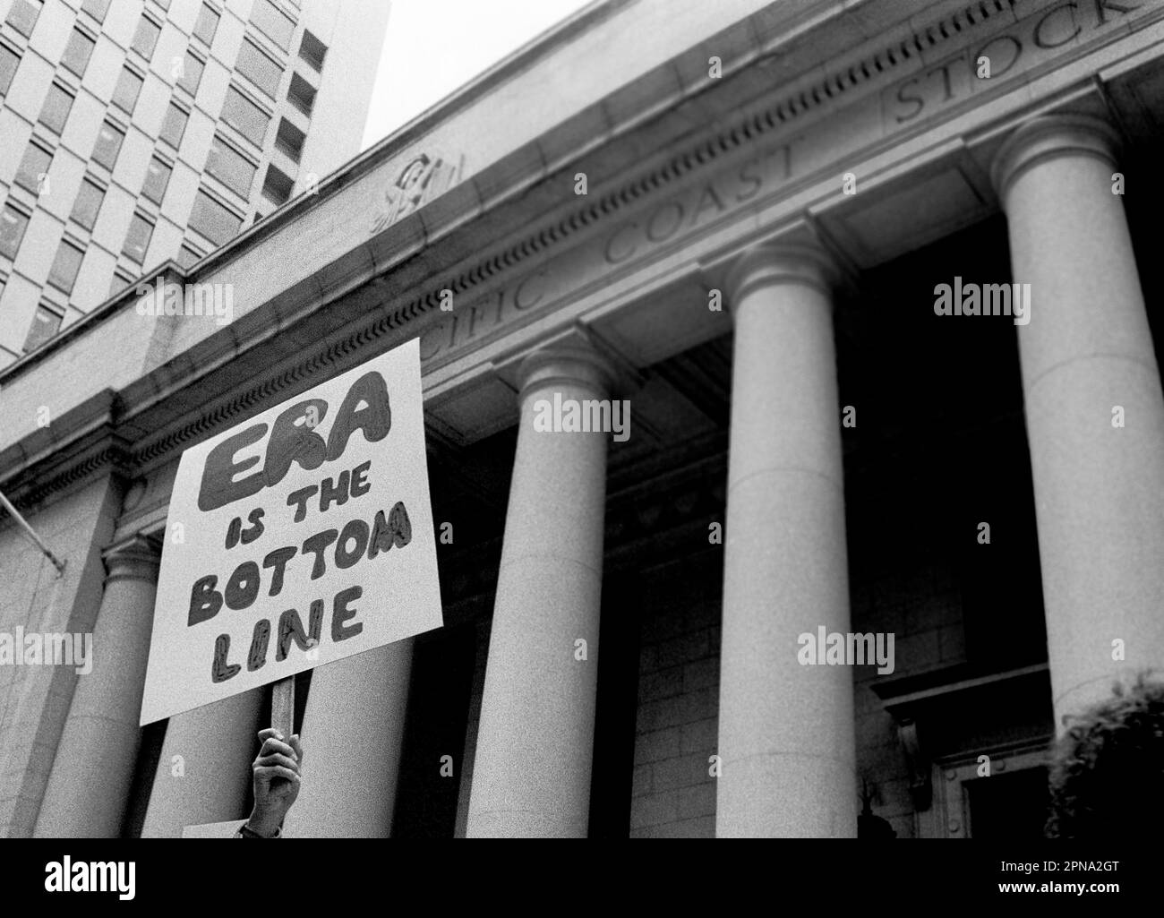 ERA è il segno di fondo che porta un dimostratore di fronte alla Pacific Stock Exchange di San Francisco, California. 1980s Foto Stock