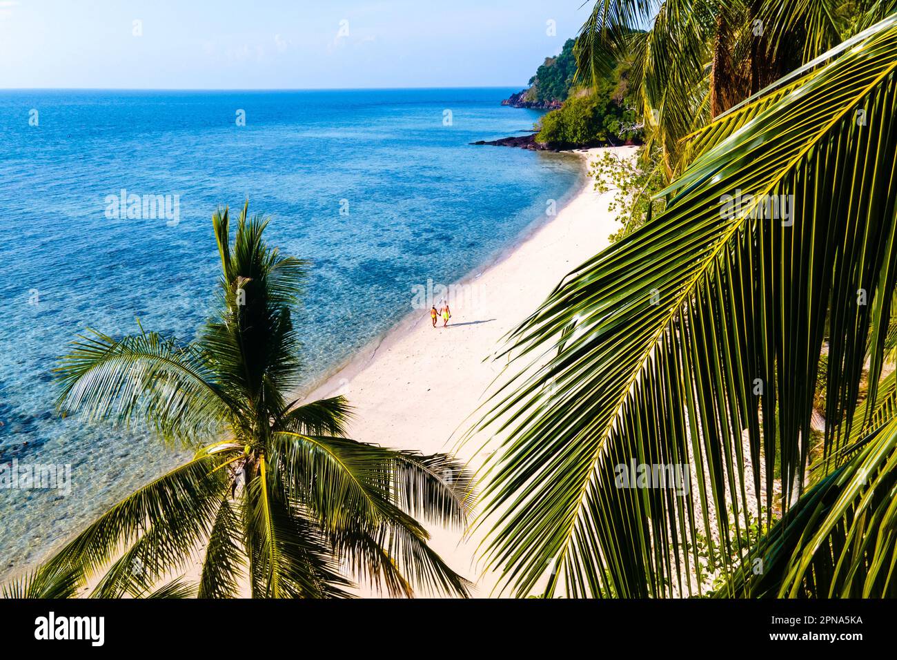 Coppia di uomini e donne sulla spiaggia di Koh kradan Island Thailandia meridionale. Vista sui droni sulla spiaggia di Koh Kradan con palme e oceano blu Foto Stock