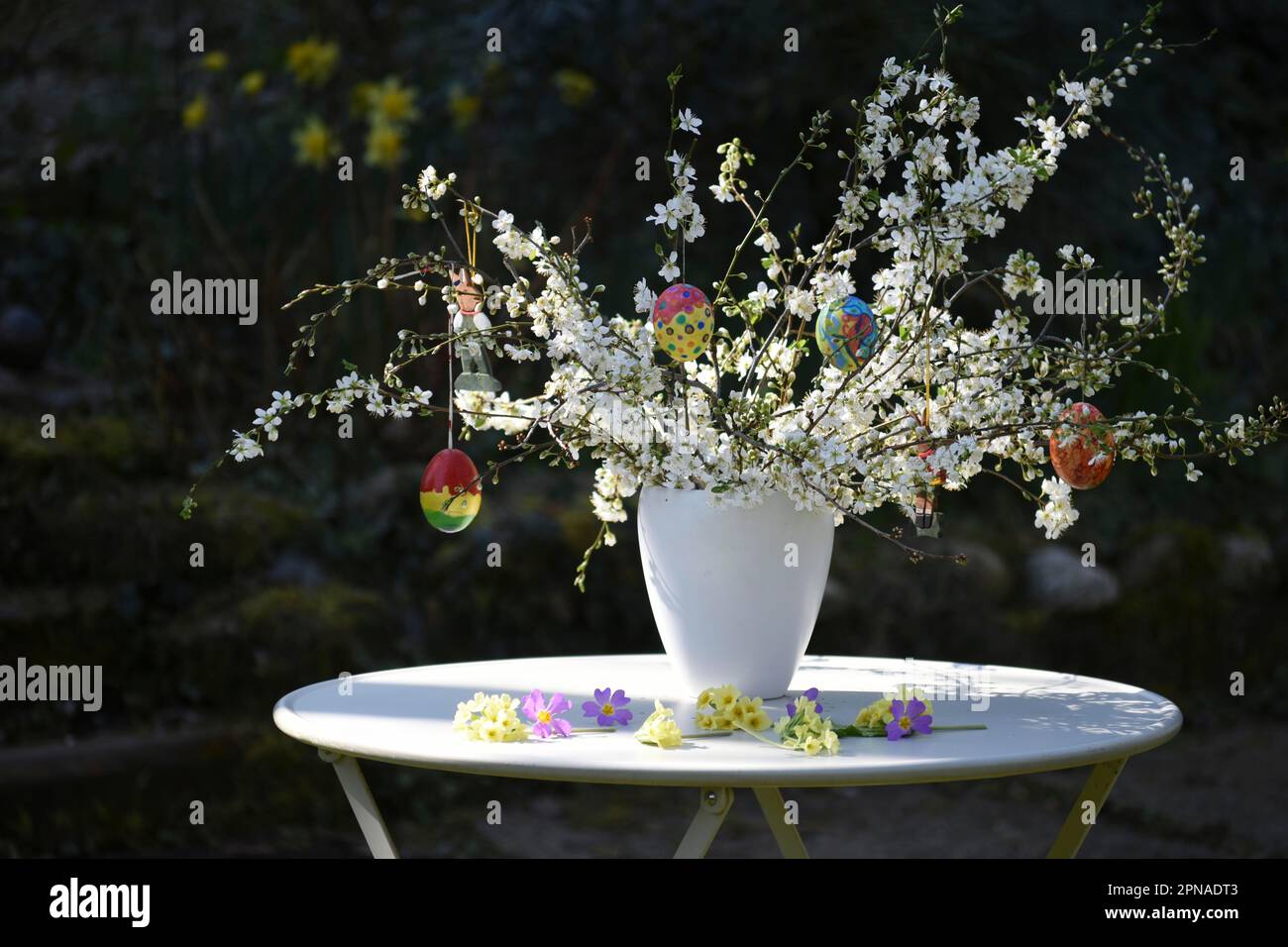 Bouquet pasquale con uova di Pasqua dipinte a mano in vaso in giardino Foto Stock