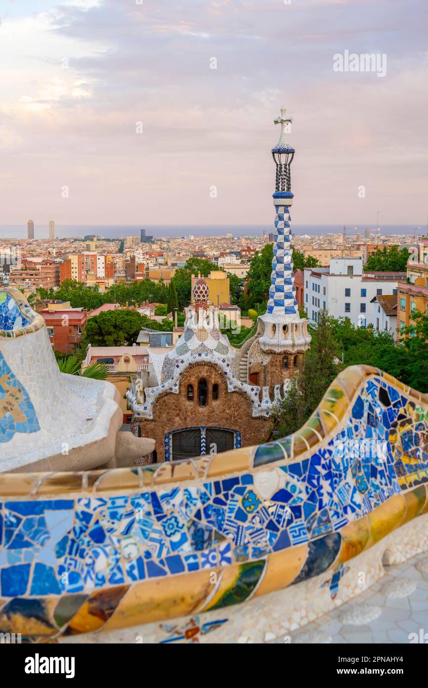 Panchine con mosaico colorato, ingresso sul retro, Pabellon de administracion, vista sulla città al tramonto, Parco Gueell, parco di Antoni Foto Stock