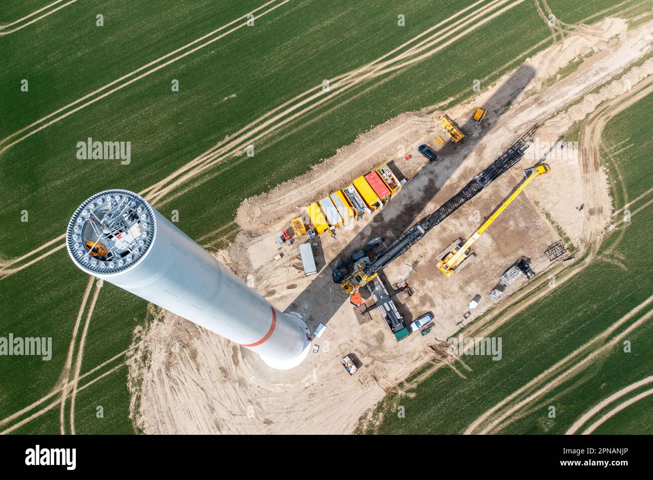 Questin, Germania. 17th Apr, 2023. Sono state assemblate le prime sezioni di torre per una nuova turbina eolica con un'altezza totale di 238 metri e una potenza di 5,7 megawatt. (Foto aerea scattata con un drone) l'Associazione statale per le energie rinnovabili si lamenta di un persistente arretrato di approvazioni per la costruzione di nuove turbine eoliche nel Meclemburgo-Pomerania anteriore. I rappresentanti dell'industria e della politica della produzione vinicola dovrebbero partecipare ad un simposio che si è tenuto a Schwerin il 18 aprile 2023. Credit: Jens Büttner/dpa/Alamy Live News Foto Stock