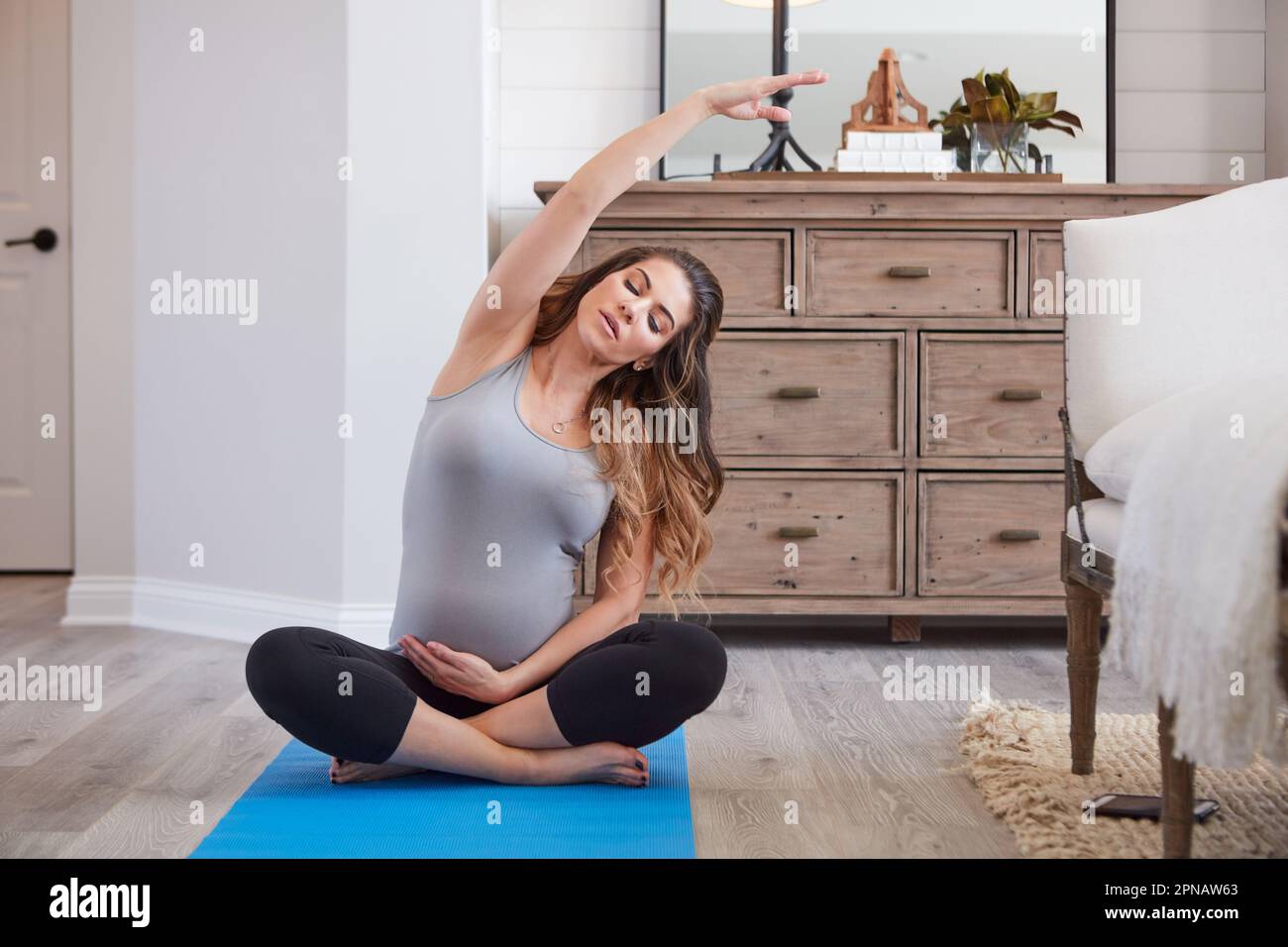 Theres nessuna resistenza come la resistenza della mamma. una giovane donna incinta che pratica una routine di yoga a casa. Foto Stock