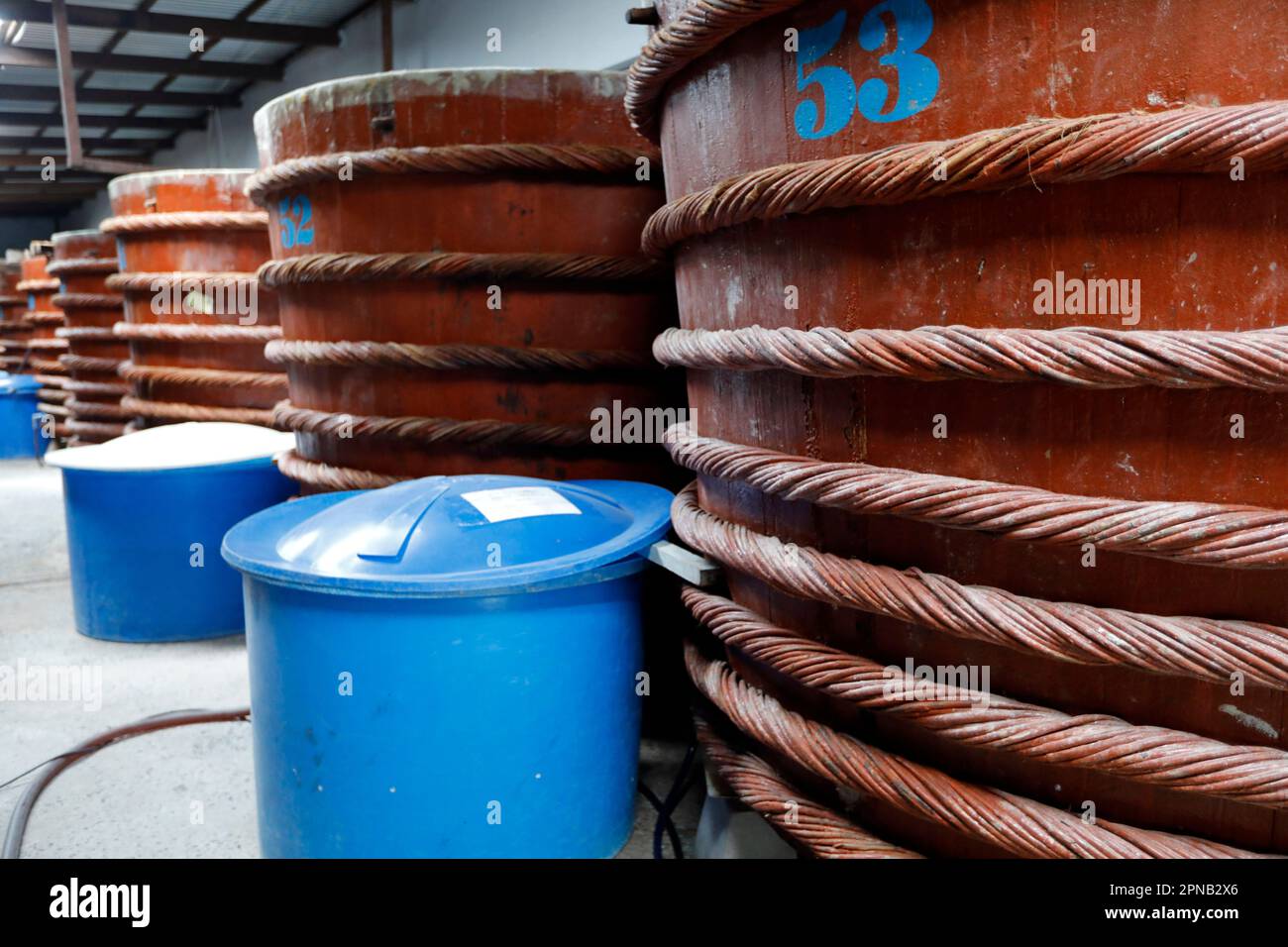 Magazzino con grandi botti di legno rosso per salsa di pesce, fabbrica di salsa di pesce, Nuoc MAM. Phu Quoc. Vietnam. Foto Stock