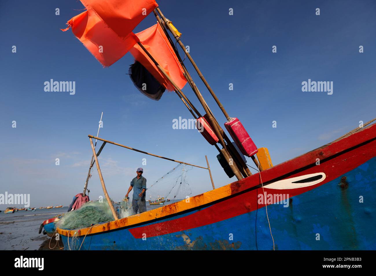 Hang Dua Bay, barca da pesca in arrivo sulla spiaggia con il fermo della notte. Barca da pesca dipinta con occhio di buona fortuna. Vung Tau. Vietnam. Foto Stock