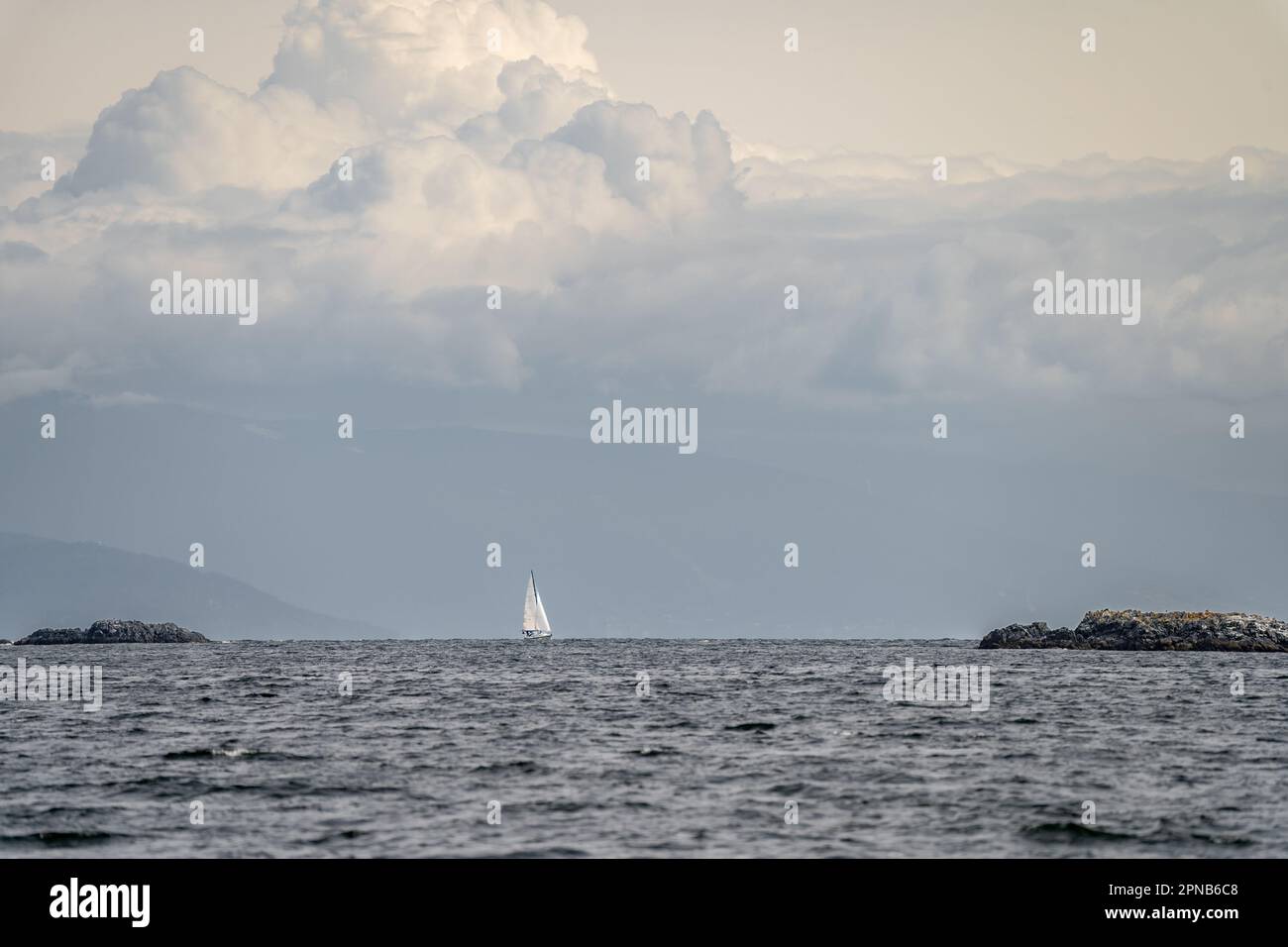 Una barca a vela naviga oltre Hudson Rocks, vicino a Nanaimo, stretto di Georgia, Isola di Vancouver, British Columbia, Canada. Foto Stock