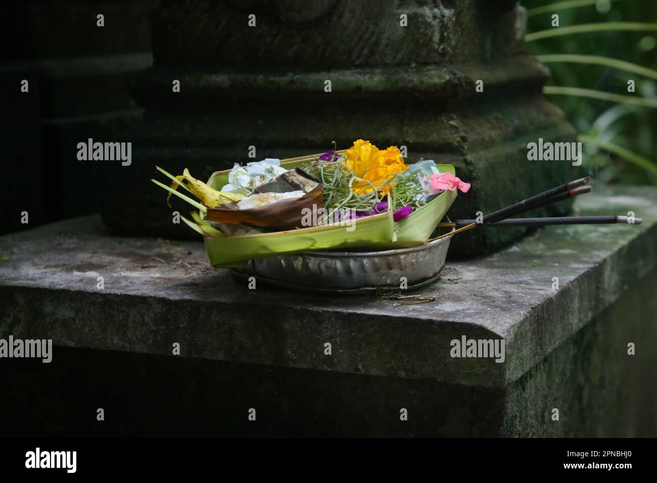 Canang sari, contenitore di bambù intessuto con riso, fiori, incenso, dolci e frutta. Si tratta di un'offerta agli dei, come gesto di gratitudine a Bali Foto Stock