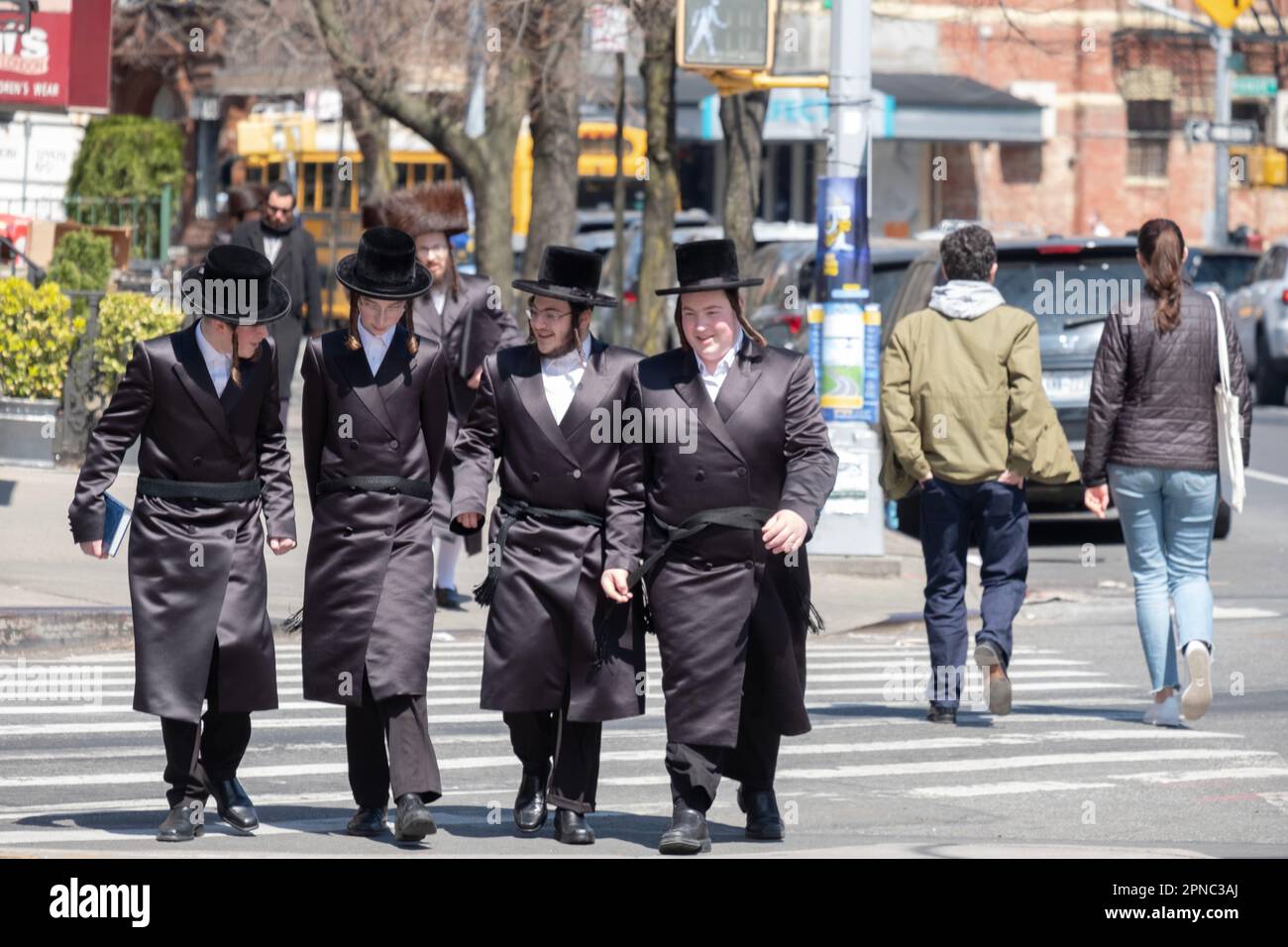 4 amici chassidici, vestiti quasi in modo identico, camminano insieme su Bedford ave. A Williamsburg, Brooklyn durante la Pasqua 2023. Foto Stock