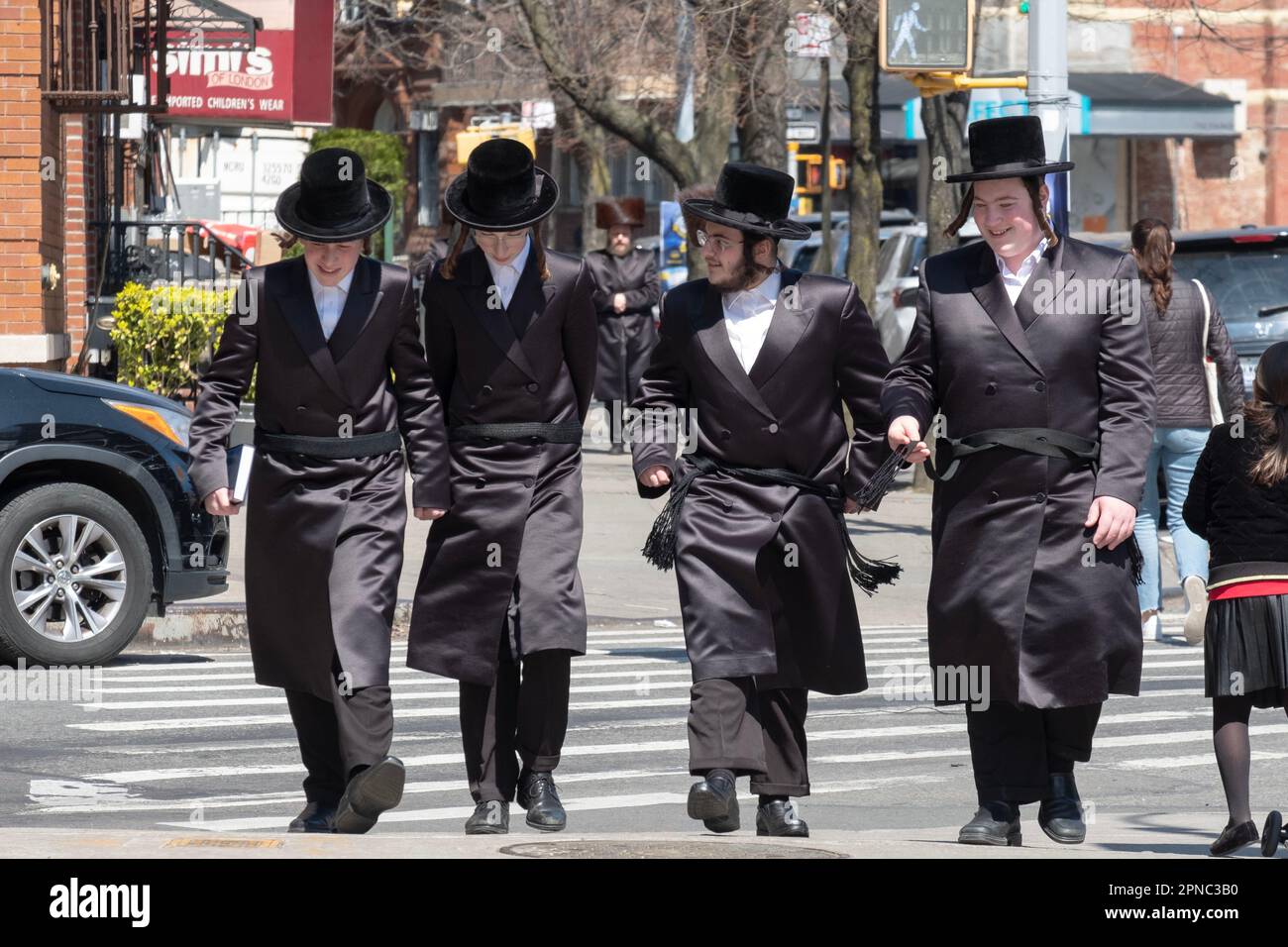 4 amici chassidici, vestiti quasi in modo identico, camminano insieme su Bedford ave. A Williamsburg, Brooklyn durante la Pasqua 2023. Foto Stock
