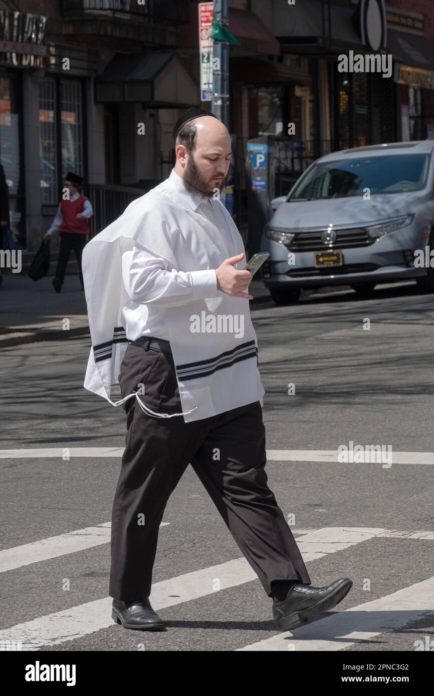 Un hassidico che indossa tzitzit, il vestito ebraico richiesto che ricorda di rispettare le leggi della Torah. Per le strade di Brooklyn, New York. Foto Stock