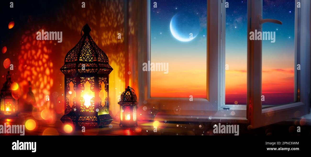 Ramadan Kareem - Lanterne arabe e finestra con Luna al Tramonto - luci defocate astratto - Eid UL Fitr - mese Santo musulmano Foto Stock