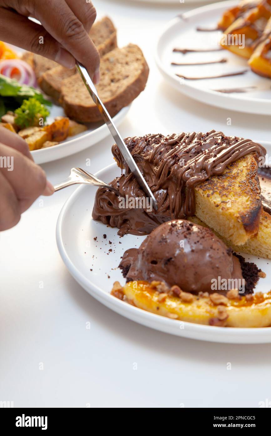 Toast alla francese al cioccolato e fetta di banana serviti con gelato al cioccolato. Foto Stock