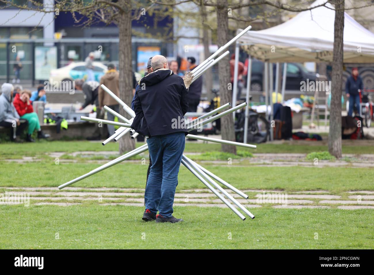 Berlino, Germania. 18th Apr, 2023. Un partecipante trasporta un palo della tenda durante lo smantellamento del campo di protesta nel Parco Invalides. I membri del movimento di ribellione delle estintioni, insieme ad altri attivisti, hanno attirato l'attenzione sulla crisi del clima e della biodiversità da una settimana a mercoledì scorso. A questo scopo avevano pianificato varie azioni, manifestazioni registrate, ma anche la disobbedienza civile ne faceva parte. Credit: Jörg Carstensen/dpa/Alamy Live News Foto Stock