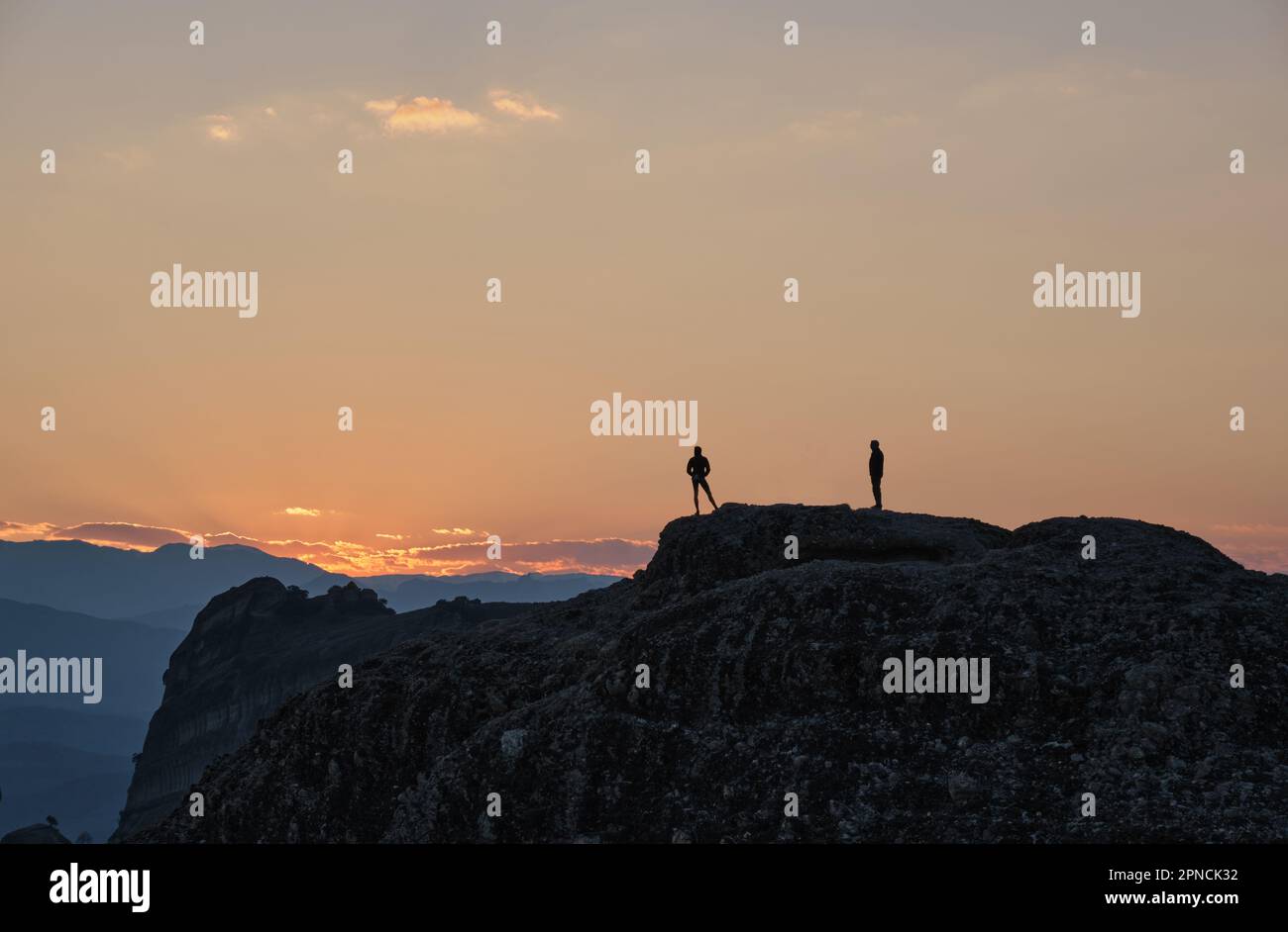 I turisti a Silhouette aspettano il sole per tramontare su Meteora in primavera Foto Stock