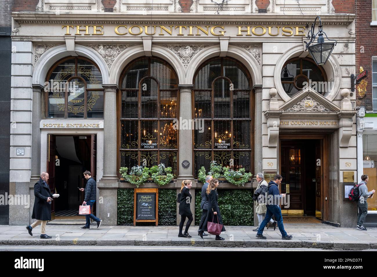 Londra, Regno Unito. 18 aprile 2023. I lavoratori della città a pranzo passano davanti alla Counting House nella città di Londra. L'Ufficio per le statistiche nazionali (ONS) ha riferito che i guadagni medi, esclusi i bonus, sono aumentati del 6,6% nei tre mesi fino a febbraio rispetto a un anno fa. Gli economisti hanno commentato che la Banca d’Inghilterra potrebbe alzare i tassi di interesse dall’attuale livello del 4,25% quando la sua commissione per la politica monetaria si riunirà il prossimo 11 maggio per combattere l’inflazione. Credit: Stephen Chung / Alamy Live News Foto Stock